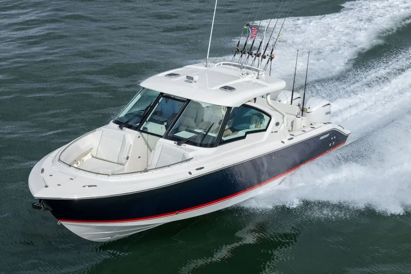 Slide: The Image of 2026 Pursuit DC 326 Dual Console boat cruising on water, equipped with fishing rods. - 6
