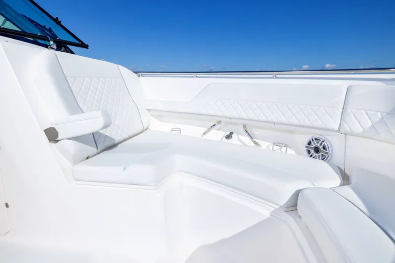 Slide: The Image of Luxurious seating on 2026 Pursuit DC 326 Dual Console boat under clear blue sky. - 9