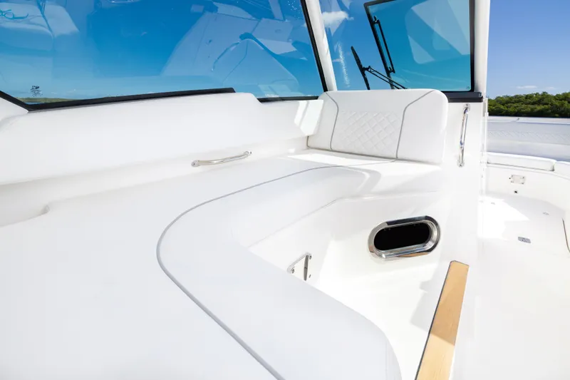 Slide: The Image of 2026 Pursuit DC 326 Dual Console boat interior with white seating and blue sky view. - 12