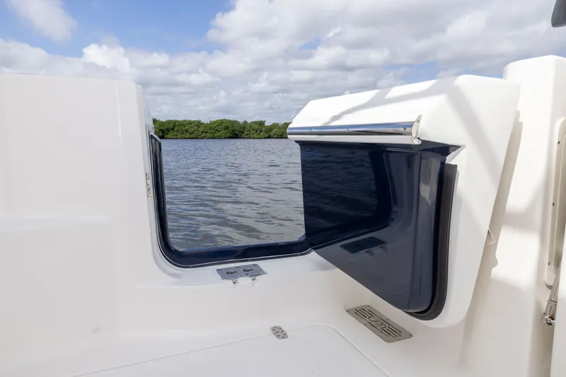 Slide: The Image of 2026 Pursuit DC 326 Dual Console boat with open transom door, overlooking calm water. - 21