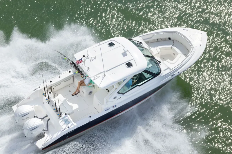 Slide: The Image of 2026 Pursuit DC 326 Dual Console boat cruising on sparkling water. - 8