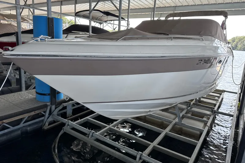 Slide: The Image of 2002 Regal 2900 LSR boat docked in a covered marina, side view. - 2