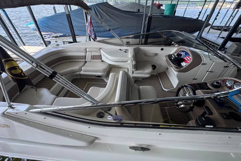 Slide: The Image of 2002 Regal 2900 LSR boat interior with seating and steering wheel, docked by the water. - 32