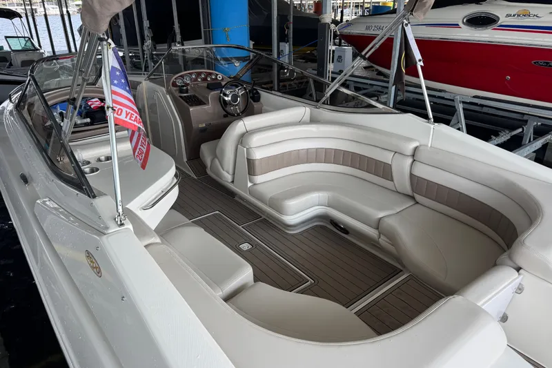 Slide: The Image of 2002 Regal 2900 LSR boat interior with plush seating and sleek dashboard in marina setting. - 33