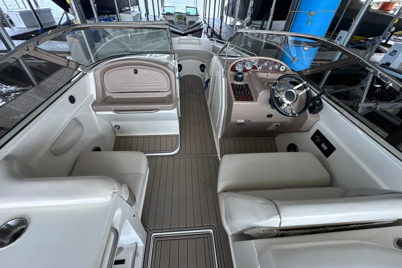 Slide: The Image of 2002 Regal 2900 LSR boat interior with steering wheel and seating in a marina. - 8