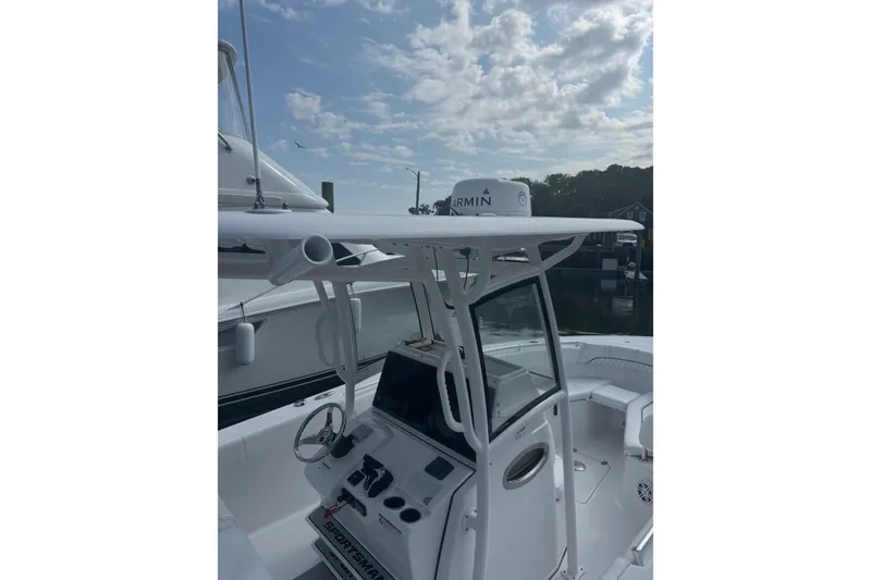 Slide: The Image of 2021 Sportsman Heritage 251 Center Console boat with Garmin equipment, docked under a cloudy sky. - 15