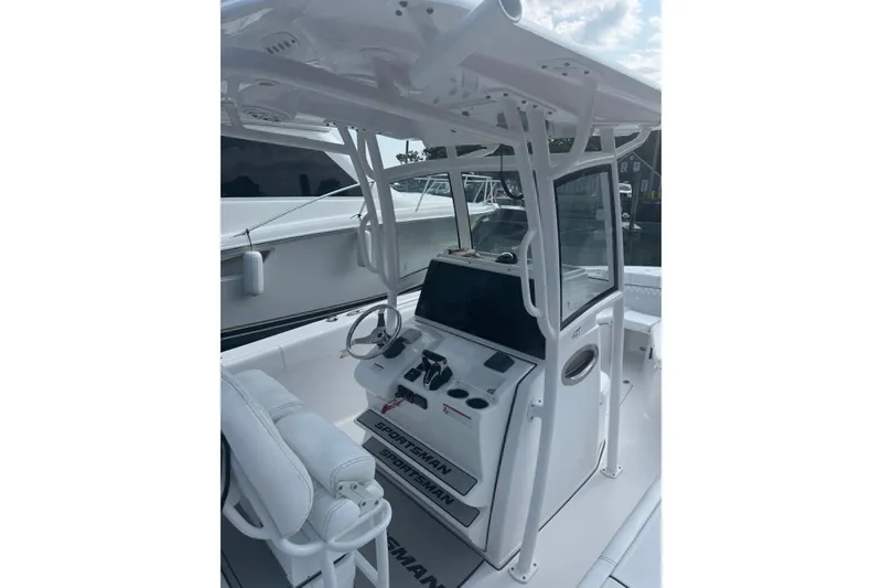Slide: The Image of 2021 Sportsman Heritage 251 Center Console boat interior with steering wheel and controls. - 13