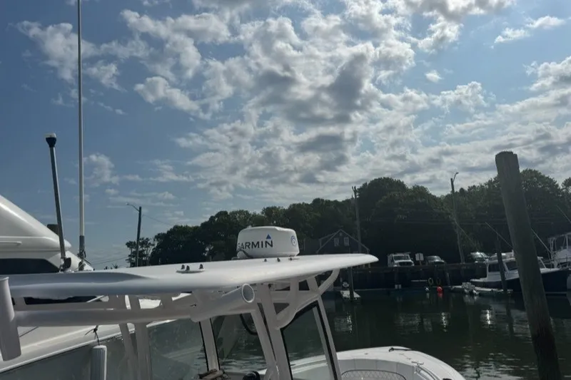 Slide: The Image of 2021 Sportsman Heritage 251 Center Console boat docked under a partly cloudy sky. - 16