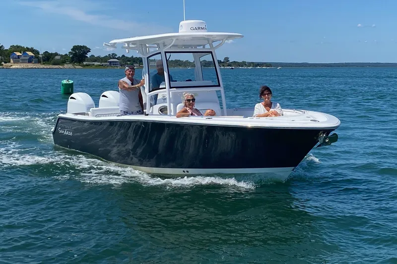 Slide: The Image of 2021 Sportsman Heritage 251 Center Console boat cruising on a sunny day with passengers. - 1