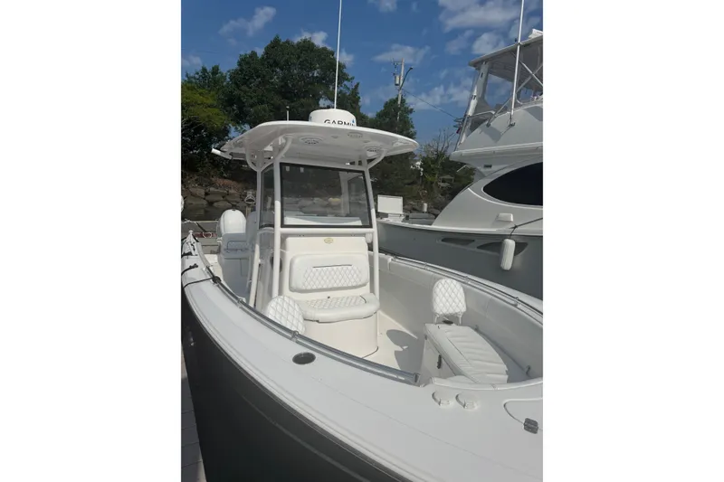 Slide: The Image of 2021 Sportsman Heritage 251 Center Console boat docked, featuring sleek design and spacious seating. - 6
