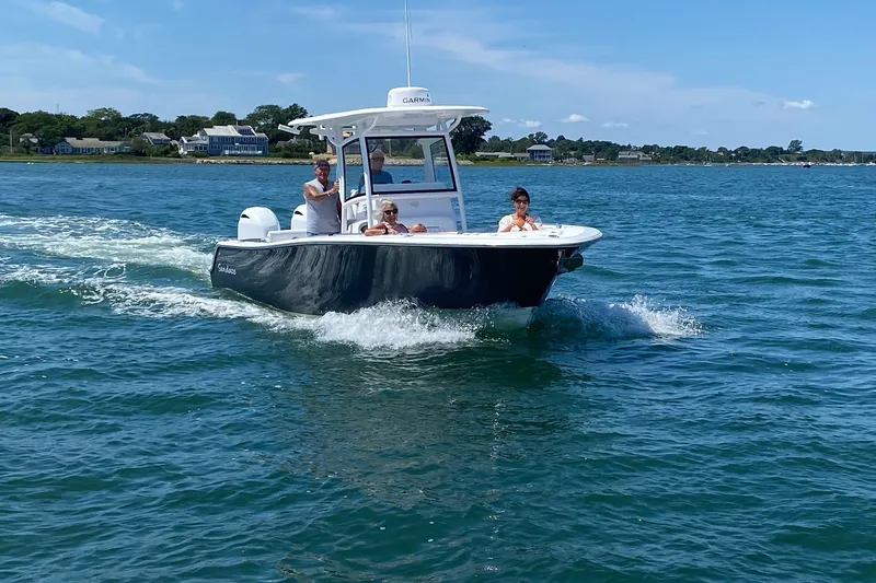 Slide: The Image of 2021 Sportsman Heritage 251 Center Console cruising on a sunny day with passengers onboard. - 5