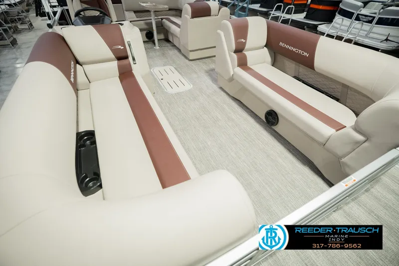 Slide: The Image of 2027 Bennington 22 SLJ pontoon boat interior with beige and brown seating, showcased by Reeder-Trausch Marine. - 14