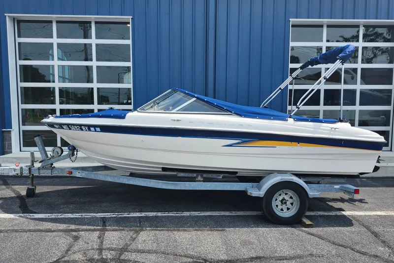 The Image of 2008 Bayliner 185 boat on trailer, parked outside blue building. - 0