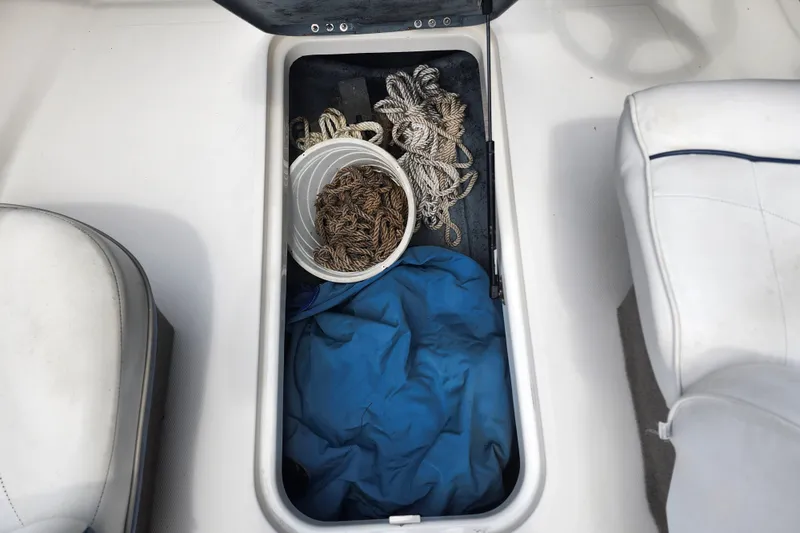 Slide: The Image of Storage compartment of a 2008 Bayliner 185 boat with ropes and a bucket. - 23