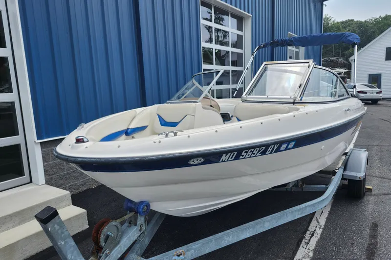 Slide: The Image of 2008 Bayliner 185 boat on trailer, parked outside a blue building. - 8