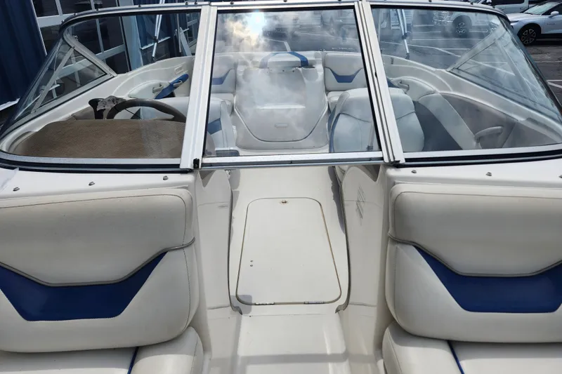 Slide: The Image of 2008 Bayliner 185 boat interior with white and blue seating, steering wheel, and windshield. - 34