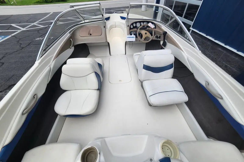 Slide: The Image of 2008 Bayliner 185 boat interior with white and blue seating, steering wheel, and dashboard. - 11