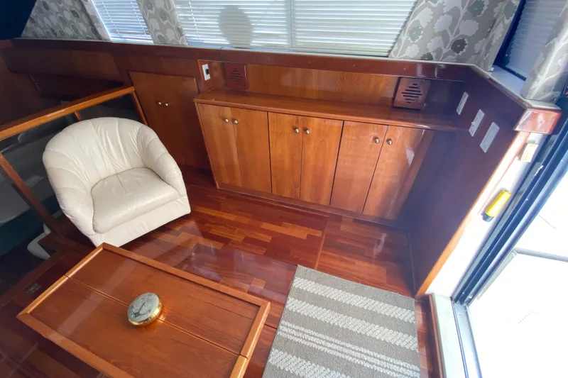 Slide: The Image of Interior of 1995 Silverton 41 Convertible yacht with wooden cabinetry and white chair. - 11