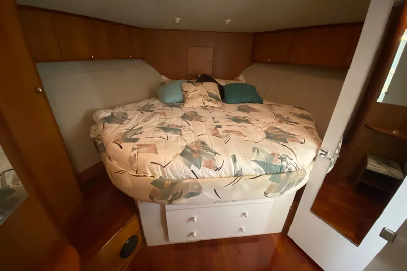 Slide: The Image of 1995 Silverton 41 Convertible cabin interior with cozy bed and wooden cabinetry. - 18