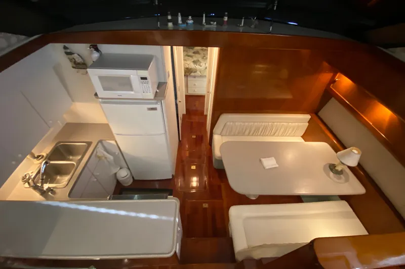 Slide: The Image of Interior of 1995 Silverton 41 Convertible yacht with kitchen and dining area. - 13