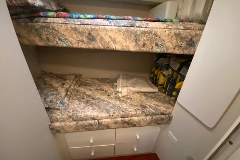 Slide: The Image of Bunk beds in 1995 Silverton 41 Convertible yacht cabin with patterned bedding and storage. - 19