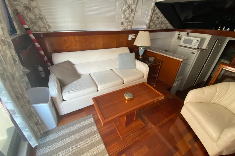 Slide: The Image of Interior of 1995 Silverton 41 Convertible yacht with cozy seating and wooden accents. - 12