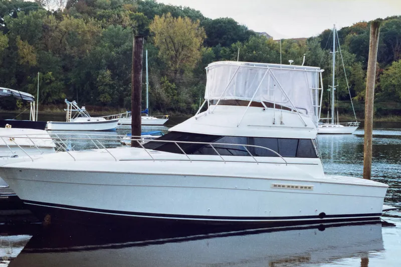 Slide: The Image of 1995 Silverton 41 Convertible yacht docked on a serene lake with lush green trees. - 29