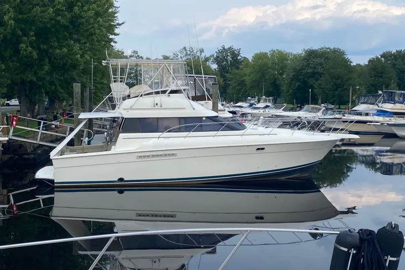 Slide: The Image of 1995 Silverton 41 Convertible yacht docked in a serene marina setting. - 1
