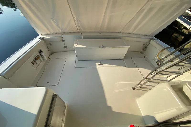 Slide: The Image of 1995 Silverton 41 Convertible boat deck with seating and storage, under a canopy. - 6