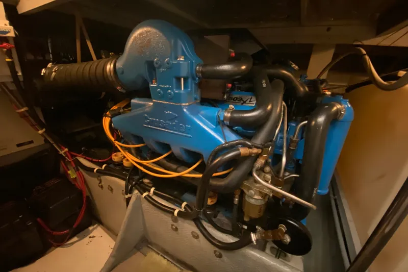Slide: The Image of Engine room of a 1995 Silverton 41 Convertible boat, featuring a blue Crusader engine. - 24
