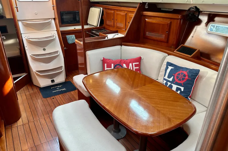 Slide: The Image of Interior of 2004 Beneteau Oceanis Clipper 393 yacht with cozy dining area and nautical decor. - 16