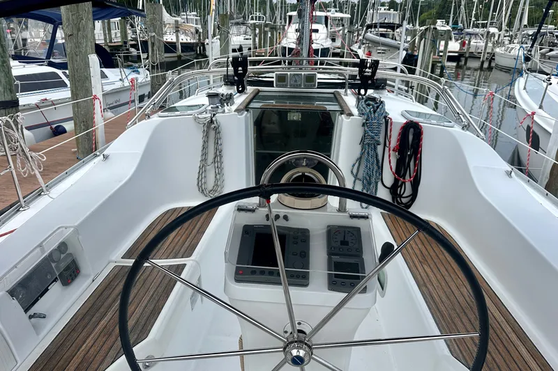 Slide: The Image of Cockpit of 2004 Beneteau Oceanis Clipper 393 sailboat, featuring steering wheel and navigation instruments. - 8