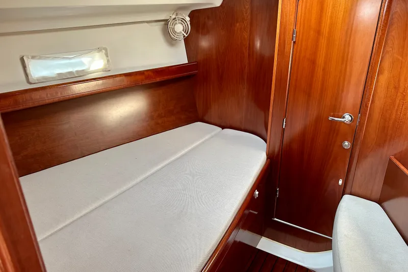 Slide: The Image of Interior cabin of 2004 Beneteau Oceanis Clipper 393 with wooden finish and cushioned berth. - 21