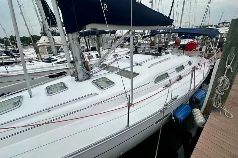 Slide: The Image of 2004 Beneteau Oceanis Clipper 393 sailboat docked at marina, featuring sleek design and blue canopy. - 5