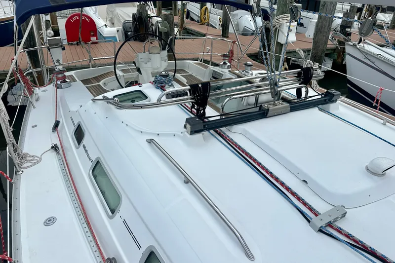 Slide: The Image of 2004 Beneteau Oceanis Clipper 393 sailboat docked, showcasing deck and steering wheel. - 13