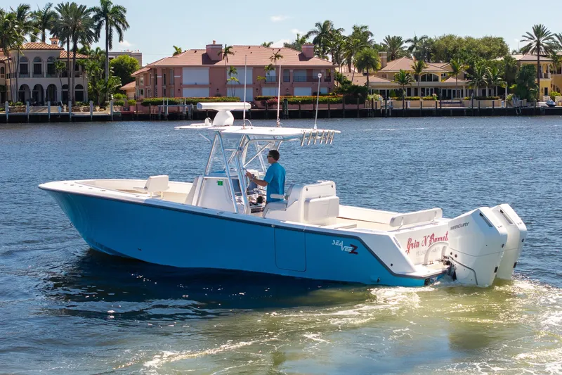 Slide: The Image of 2025 SeaVee 322Z boat cruising on a sunny waterfront with luxury homes in the background. - 4