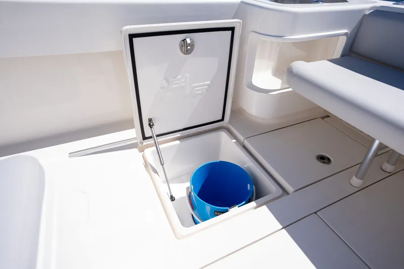 Slide: The Image of 2025 SeaVee 322Z boat storage compartment with blue bucket and seating area. - 14