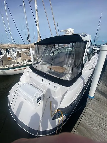 Slide: The Image of A 2018 Four Winns 355 Vista docked. It features a black canopy and clear windows. - 6