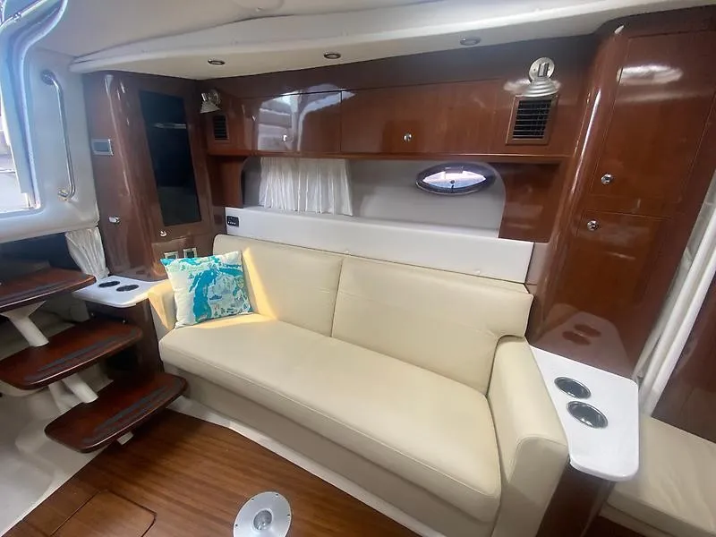 Slide: The Image of Interior of the 2018 Four Winns 355 Vista with cream sofa and wood accents. - 17