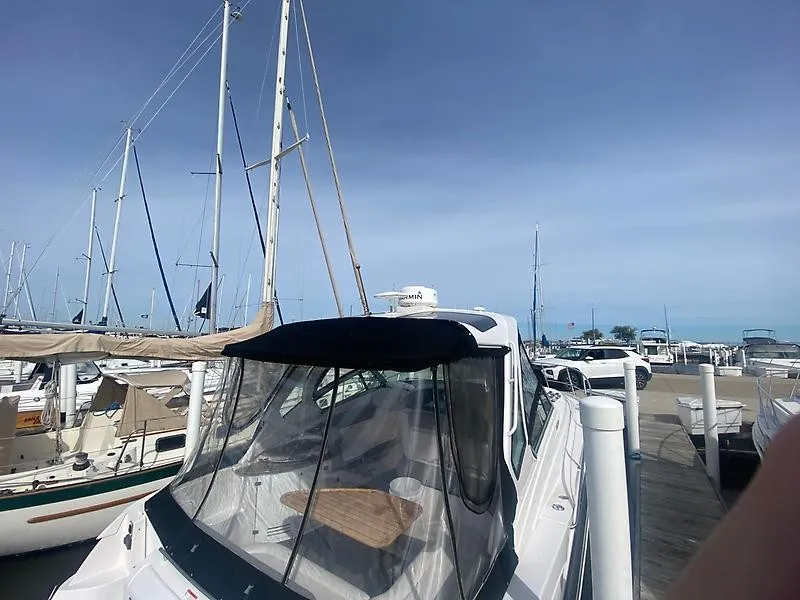 Slide: The Image of A 2018 Four Winns 355 Vista docked at a marina, surrounded by other sailboats. - 7