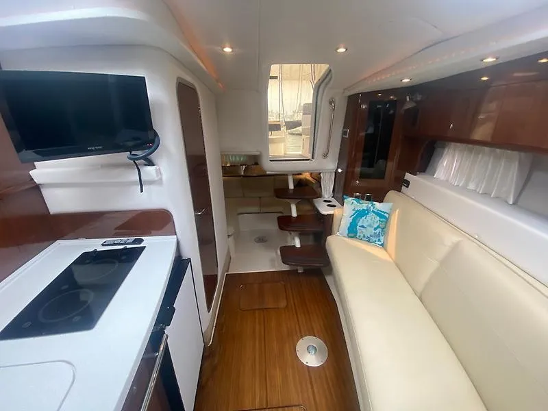 Slide: The Image of Interior of the 2018 Four Winns 355 Vista with sleek design, kitchenette, and cozy seating area. - 18
