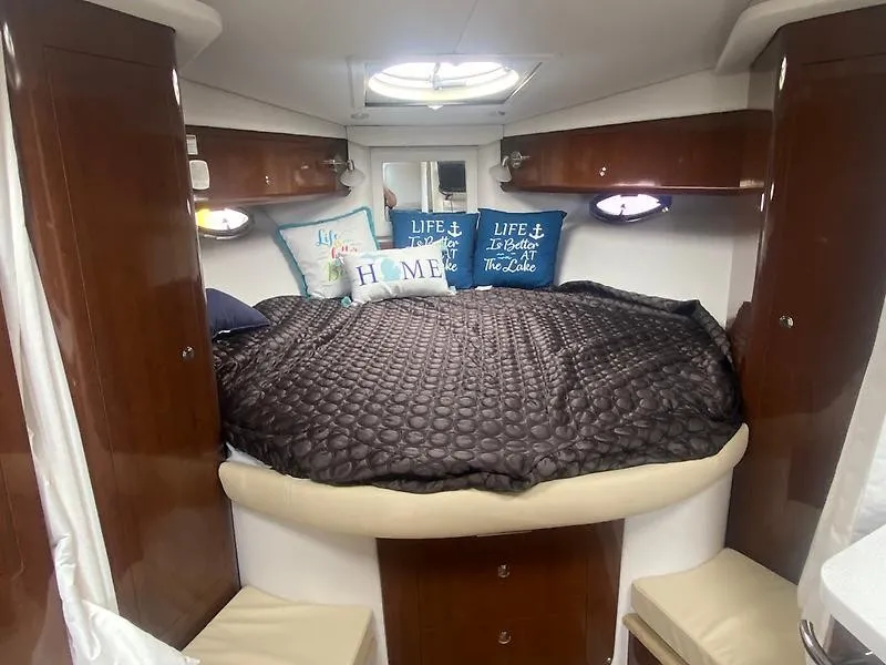 Slide: The Image of Cabin of the 2018 Four Winns 355 Vista with a cozy bed and decorative pillows. - 16