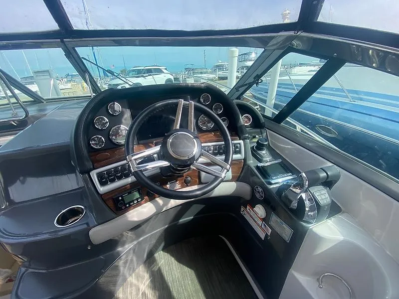 Slide: The Image of The image shows the cockpit of a 2018 Four Winns 355 Vista with a sleek steering wheel and instruments. - 12