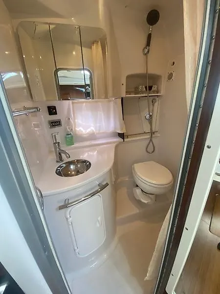 Slide: The Image of The image shows a modern boat bathroom with a sink, toilet, and shower. - 21