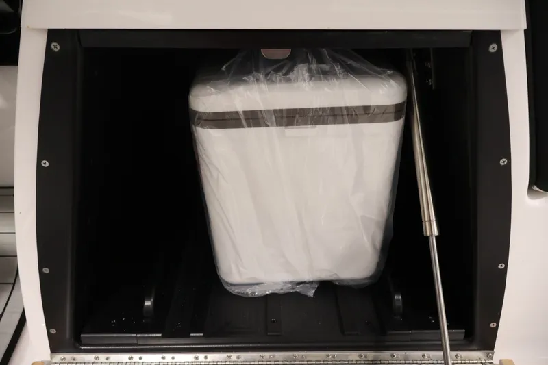 Slide: The Image of Storage compartment in 2026 Yamaha Boats 275SE, featuring a secured white cooler. - 32