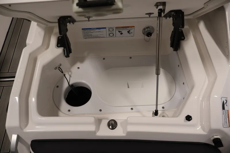 Slide: The Image of 2026 Yamaha Boats 275SE storage compartment with hydraulic lift and safety instructions. - 42