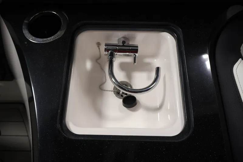 Slide: The Image of 2026 Yamaha Boats 275SE sink with chrome faucet and cup holder. - 33