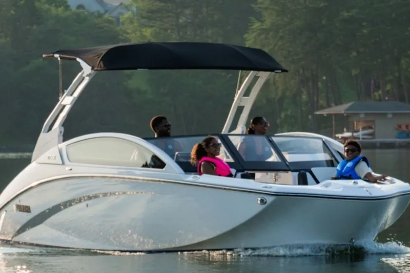 The Image of 2020 Yamaha Boats 275SE cruising on a serene lake with passengers enjoying the ride. - 2