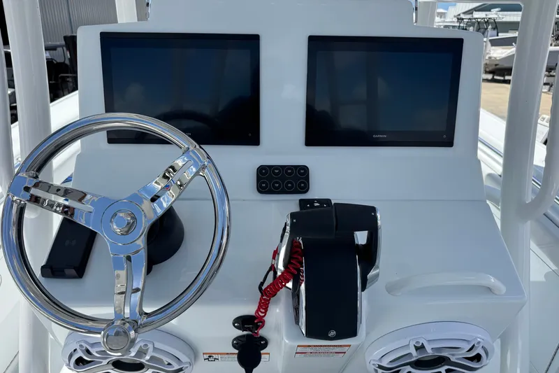 Slide: The Image of 2027 Yellowfin 26 Hybrid boat dashboard with dual screens and steering wheel. - 18