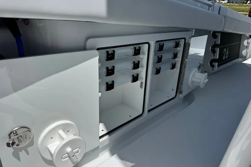 Slide: The Image of 2027 Yellowfin 26 Hybrid boat storage compartments with open doors, showcasing interior organization. - 17